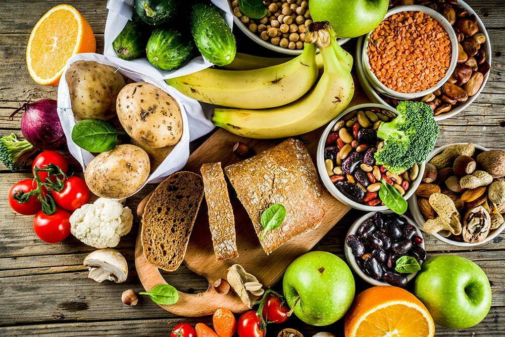 Healthy food. Selection of good carbohydrate sources, high fiber rich food. Low glycemic index diet. Fresh vegetables, fruits, cereals, legumes, nuts, greens. Wooden background copy space