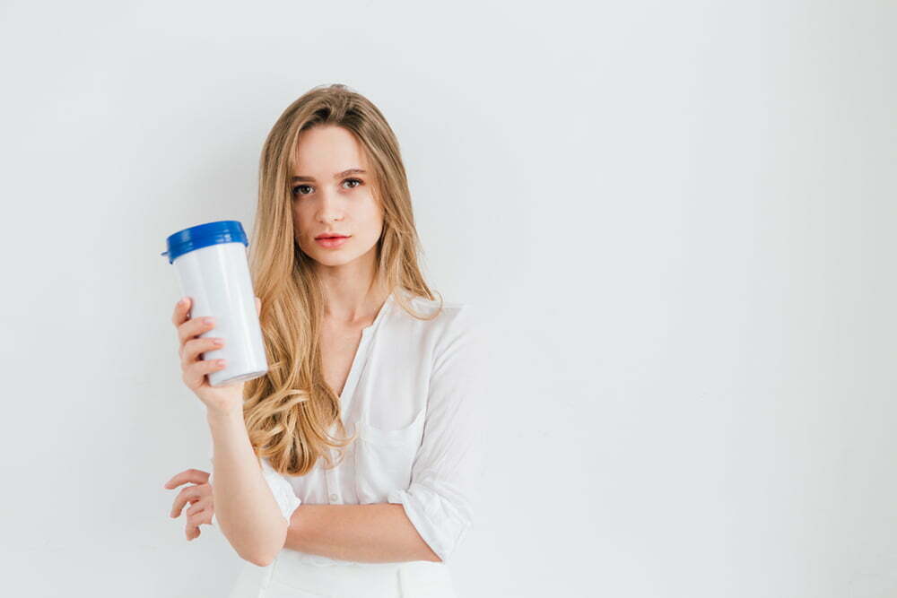 Young beautiful girl holding a useful reusable glass for comparison. The concept of sustainability and zero waste. Toning.