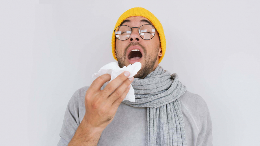 portrait-sick-handsome-man-wearing-grey-sweater-yellow-hat-spectacles-blowing-nose-sneeze-into-tissue-male-have-flu-virus-allergy-respiratory-healthy-medicine-people-concept